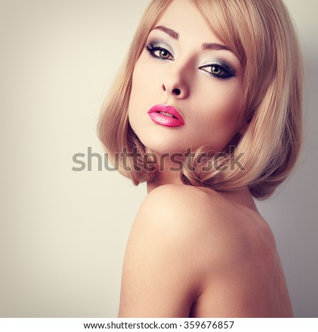 Beautiful makeup woman with green eyes and pink lipstick. Short hairstyle. Closeup toned portrait