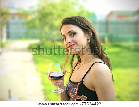 Beautiful girl drinking red wine outdoor. In the park. Sunny day
