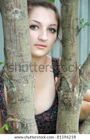 Beautiful girl among the trees with romantic look
