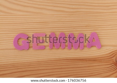 The female name Gemma made from foam letters on a wooden background