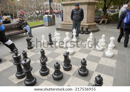 MELBOURNE, AUSTRALIA - August 29 2014:Two Men playing a game of outdoor chess outside of the State Library of Victoria, Popular pastime with visitors.