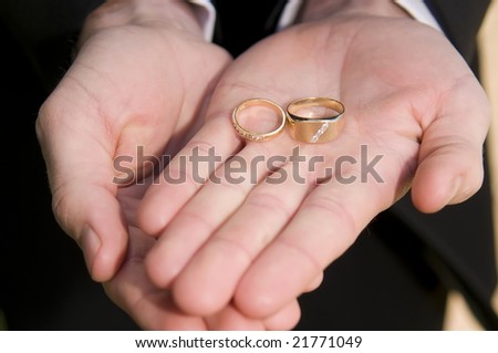 Best man holding the wedding rings, close up with shallow depth of field focus on rings