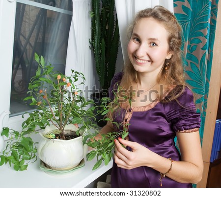Smiling girl with plant at home