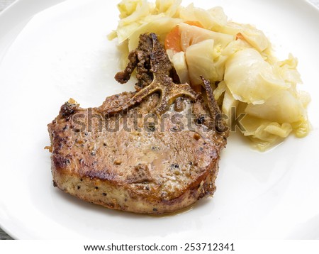 Meal of roasted rib eye meat with cabbage on white plate