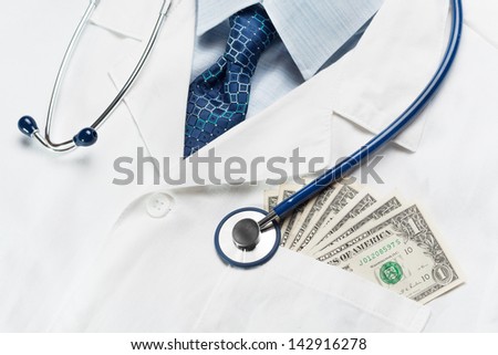 Closeup of doctor\'s coat with money in the pocket symbolizing costly healthcare or corruption.