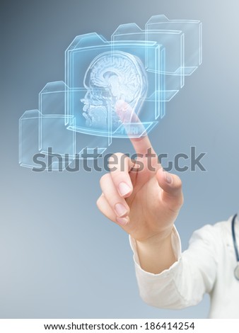 Hand pushing futuristic button and performing magnetic resonance of human brain.