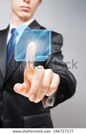Businessman pressing high-tech virtual button with copy space.