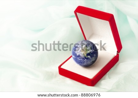 Planet Earth in a jewel box as a precious gift to protect. Image with copy space on the left. Earth globe image provided by NASA.