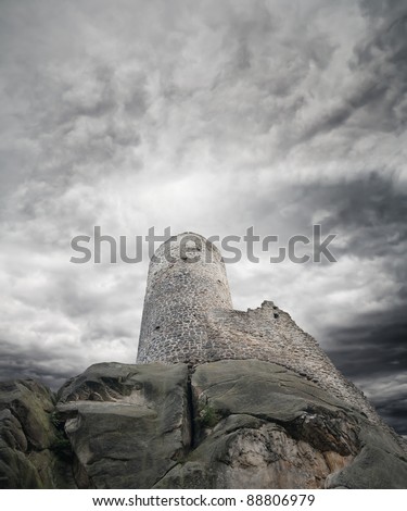 Ruins of spooky dark castle with with storm clouds in the background.
