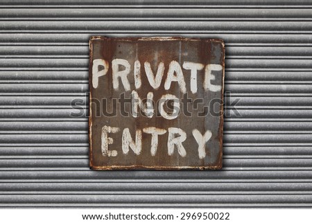 Rusty metal private, no entry sign on metal shutter background