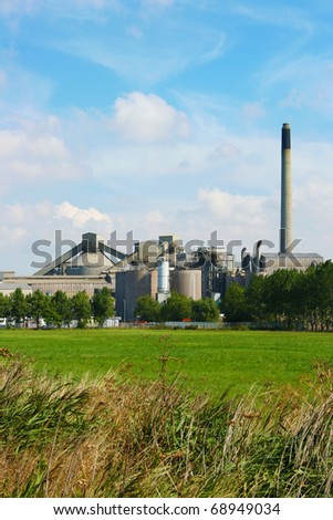 Green field in front of a cement factory