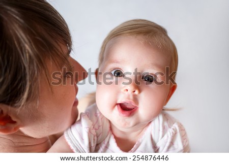Mother holding sweet smiling baby girl