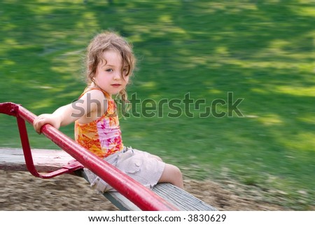 a little girl spinning on a merry-go-round