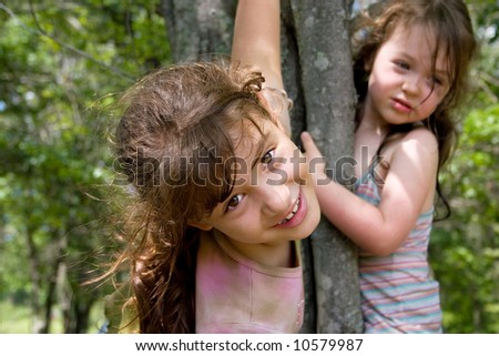 stock photo Two little girls climbing a tree