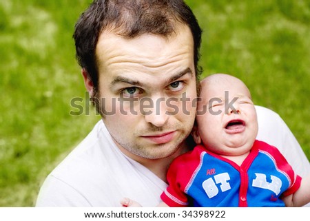 A concerned father holding a crying baby