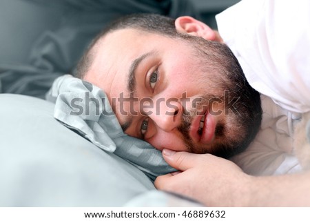 a man laying in bed looking like he is sick
