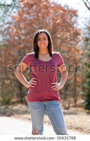 a beautiful young girl standing outside in short sleeves