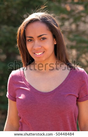a beautiful young girl standing outside in the sun
