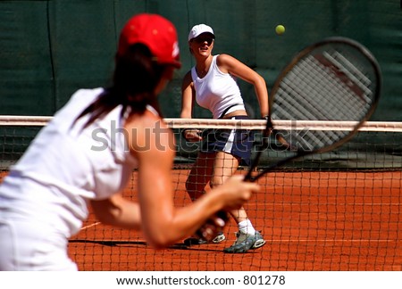 Two young sporty female tennis players enjoying a game in the sun on the Costa del Sol