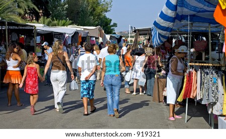 People and crowds walking through a Spanish Sunday market on a sunny day on the Costa del Sol