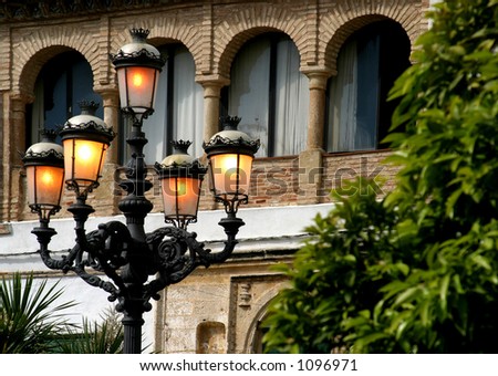 Yellow orange glow from rustic old street lamps early evening in Spain