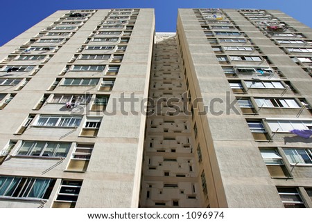 Abstract converging lines of a tall high rise apartment block with many windows on a bright sunny day