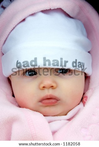 Pretty baby girl with funky hat on that says bad hair day