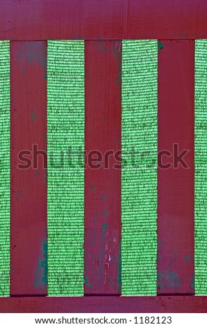 Wooden fence with green background that looks like cricket stumps or roman numerals for three
