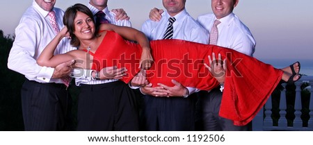 Smart wealthy young woman in a red dress being lifted by four men at a dinner party by the sea