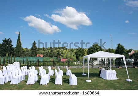 Empty white seats at an outdoor wedding in the sun