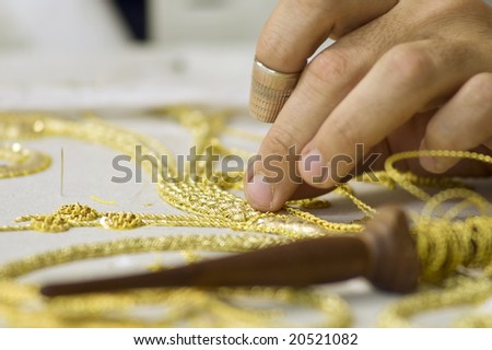The first plane of a woman realizing embroidery in gold