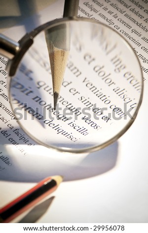 Image of the increase with a magnifying glass of the top of a pencil that this checking text