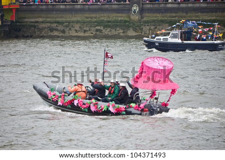 LONDON, UK-JUNE 3:A boat called Anne decorated with a large pink hat representing one of the Queen\'s hats, takes part in the Queen\'s Diamond Jubilee pageant of a 1,000 ships. June 3, 2012 in London UK