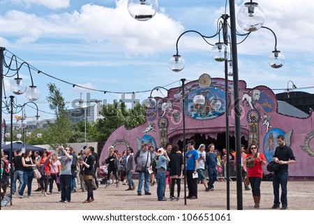 LONDON, UK-JUNE 30: Visitors enter Paradise Gardens cultural festival's opening day in London's Pleasure gardens, set in the post industrial area of the Royal Docks. June 30, 2012 in London UK
