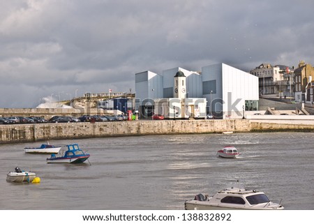 MARGATE,UK-FEBRUARY 2: View of The Turner Contemporary Gallery and Droit House, across the harbour during stormy weather. Waves break over the sea wall in the background. February 2, 2013 Margate UK