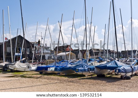 WHITSTABLE, UK-MAY 16: A line of boats lie docked in Whitstable harbour with weathered huts and buildings behind. Whitstable is famous for its oysters and oyster festival.May 16, 2013 in Whitstable UK