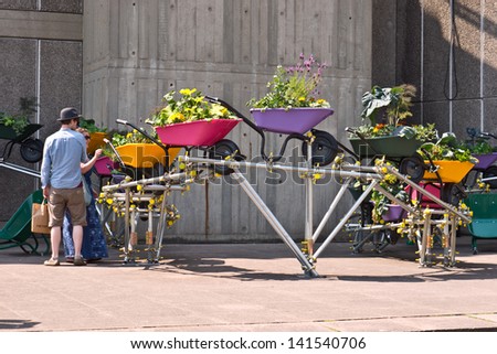 LONDON,UK-JUNE 6: An urban wheelbarrow garden is enjoyed by visitors to the Southbank's festival of neighbourhood, that brings urban gardens and allotments to the centre. June 6, 2013 London UK.