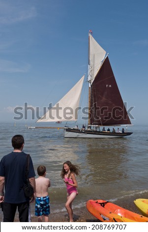 WHITSTABLE, UK-JULY 27: Visitors and boat owners enjoy the sea at Whitstable where thousands of visitors attend the annual Whitstable Oyster Festival. July 27, 2014 , Whitstable Kent UK.