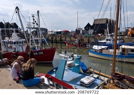 WHITSTABLE, UK-JULY 27: Visitors and boat owners enjoy the Harbour at Whitstable where thousands of visitors attend the annual Whitstable Oyster Festival. July 27, 2014 , Whitstable Kent UK.