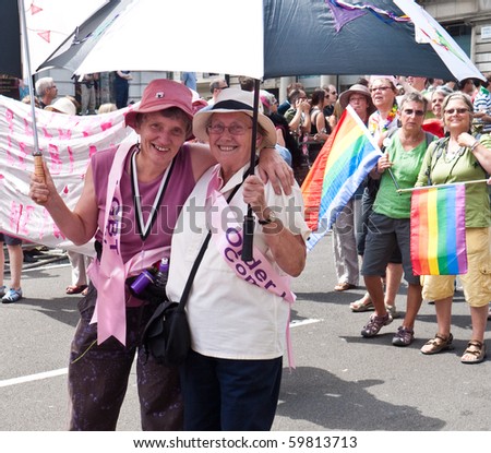 LONDON, UK-JULY 3: The Gay Pride Parade Passes Through Piccadilly in London, Two Senior Woman Are Smiling Holding an Umbrella As A Sunshade, July 3, 2010 in London, UK