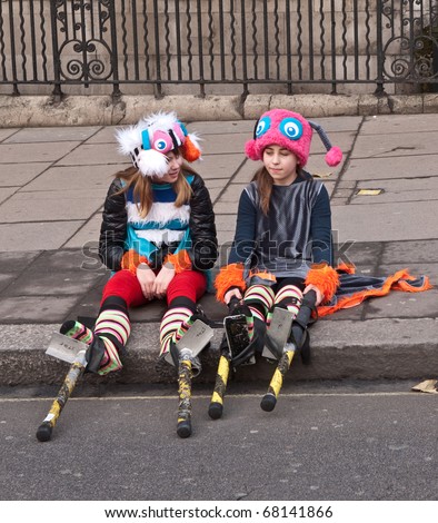 LONDON, UK- JANUARY 1: Two Young unidentified girls in costumes with stilts sitting waiting their turn in the Annual New Year\'s Day Parade on January 1, 2011 in London, UK.