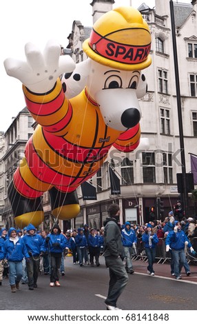 LONDON, UK- JANUARY 1: Giant Inflatable Sparky the Dog in Fireman\'s Suit carried past parade goers in the Annual New Year\'s Day Parade on January 1, 2011 in London, UK.