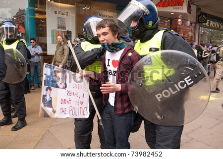 LONDON, UK- MARCH 26:Two riot police officers talk to a protester on Oxford Street, during the day of protests over Government cuts in central London.March 26, 2011 in London, UK.
