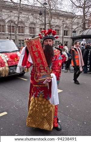 LONDON, UK-JANUARY 29: Unidentified man in a traditional Chinese  costume takes part in a parade, part of the famous London celebrations for the year of the dragon, January 29, 2012 in London UK