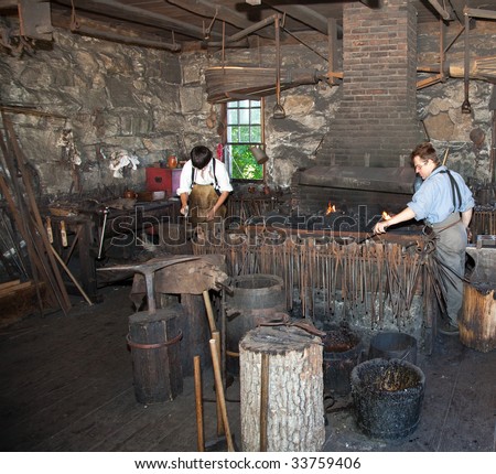 OLD STURBRIDGE VILLAGE, MA - JULY 15: Period actors recreate working in a Blacksmith Shop for visitors on July 15, 2009 in Old Sturbridge Village, MA.