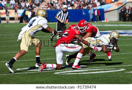 EL PASO – DECEMBER 31:  UTAH\'s Black (9) and Shelby (90) tackle Georgia Tech\'s Jones (20) during UTAH\'s overtime 30 to 27 win over Georgia Tech at the Sun Bowl on December 31, 2011 in El Paso, Texas.