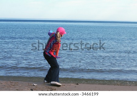 girl throwing rocks in a lake