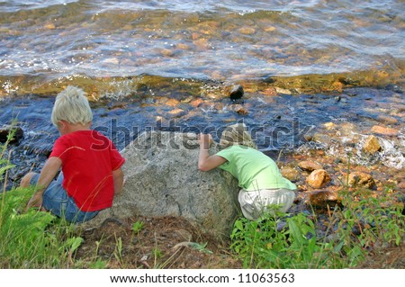 Young kids throwing rocks at the lake