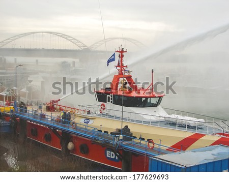 GORINCHEM, THE NETHERLANDS - FEBRUARY 13, 2012 : Ship melts the ice by steam gun in the harbor of Gorinchem