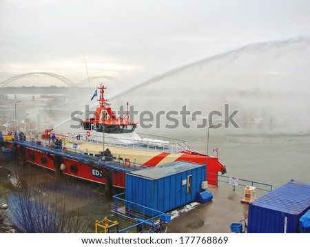 GORINCHEM, THE NETHERLANDS - FEBRUARY 13, 2012 : Ship melts the ice by steam gun in the harbor of Gorinchem